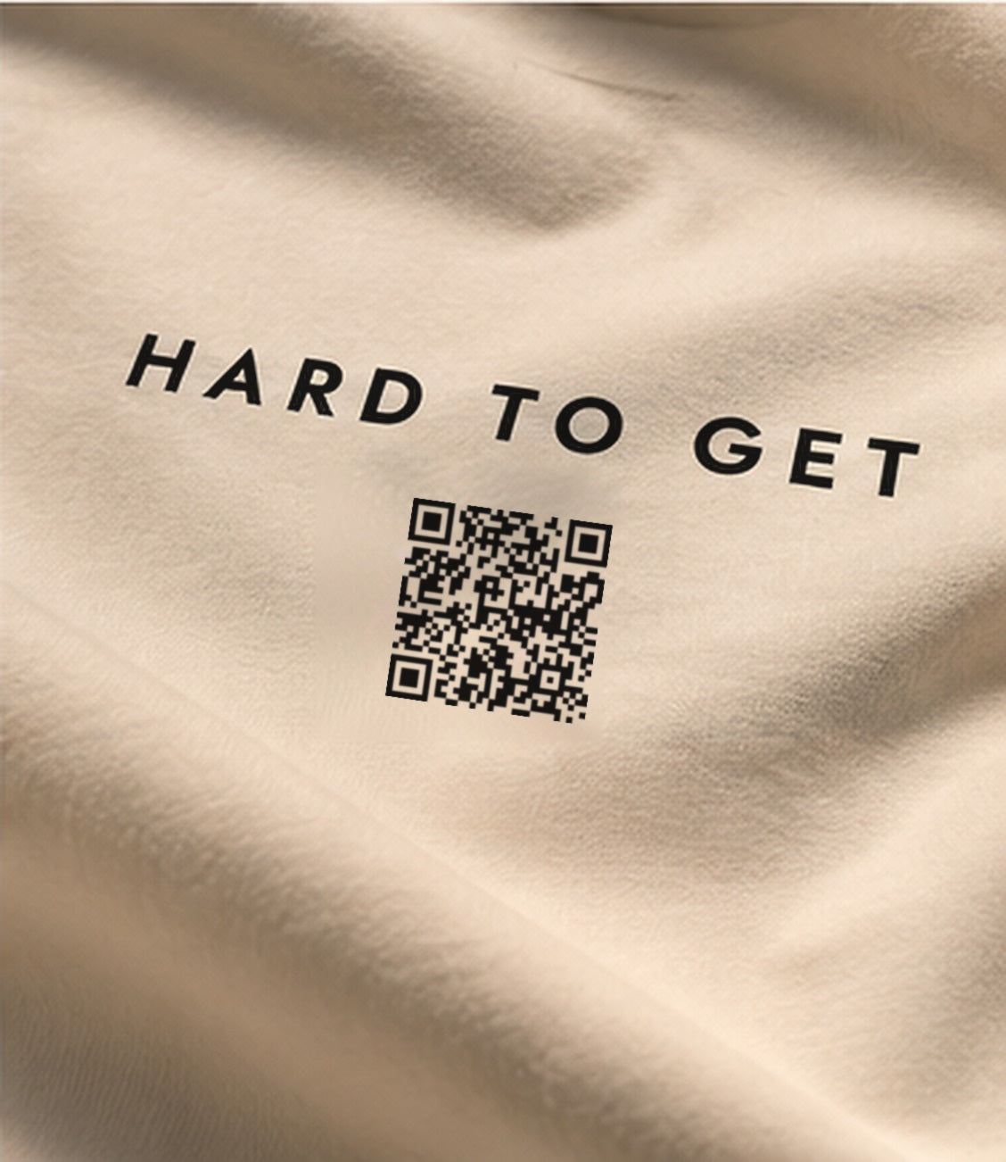Hard to Get tee in Cream, close-up of the HARD TO GET print and QR code